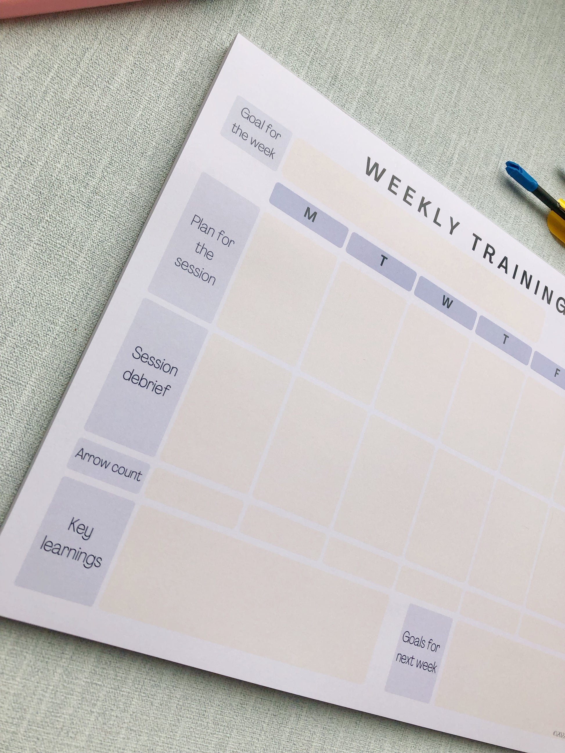 Purple themed archery weekly planner. With different sections titled, goal for the week, plan for the session, session debrief, arrow count, key learnings, and goal for next week.