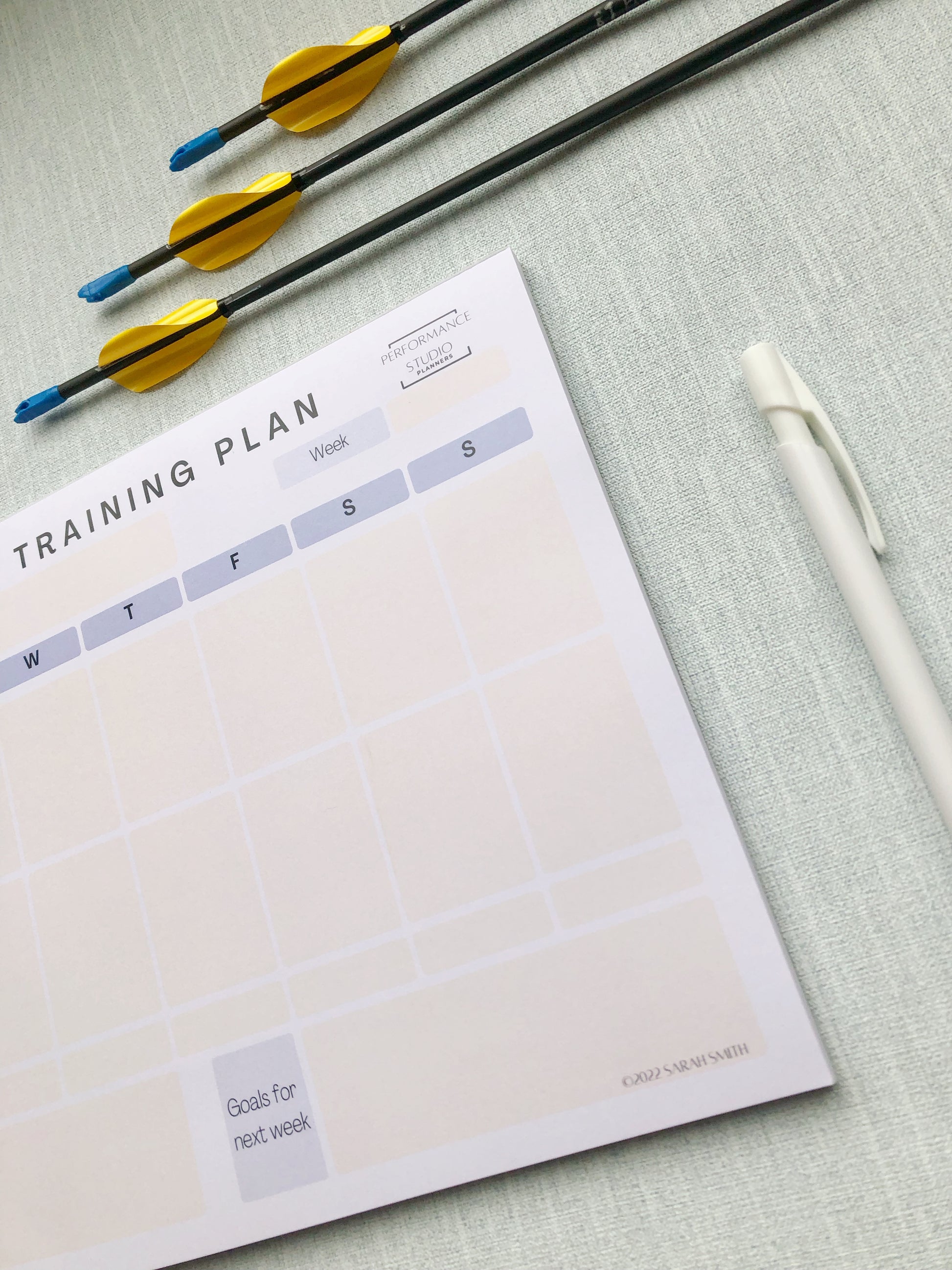 Purple themed archery weekly planner. With different sections titled, goal for the week, plan for the session, session debrief, arrow count, key learnings, and goal for next week.